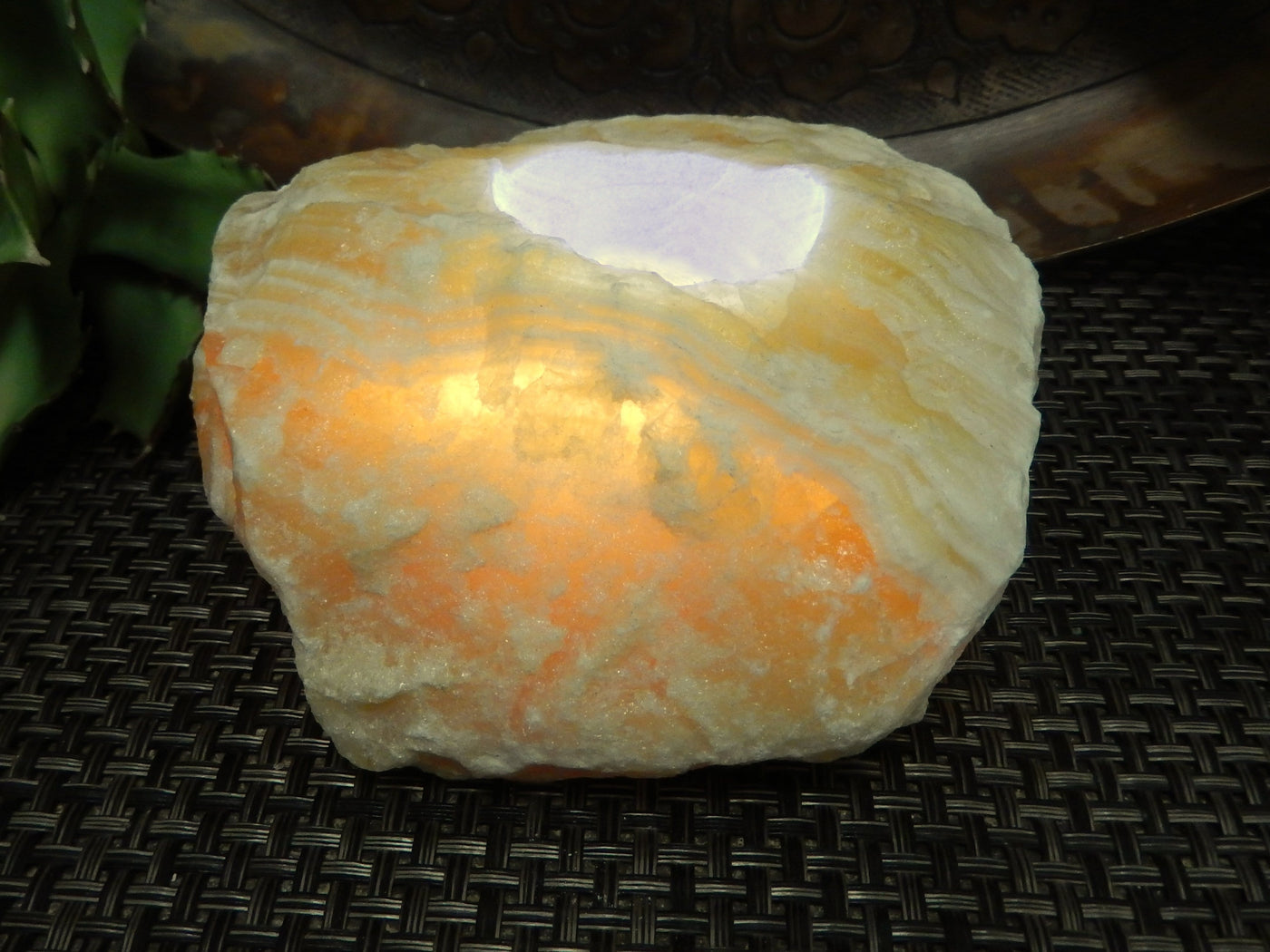 A Lit Mexican Orange Calcite Candle Holder up close