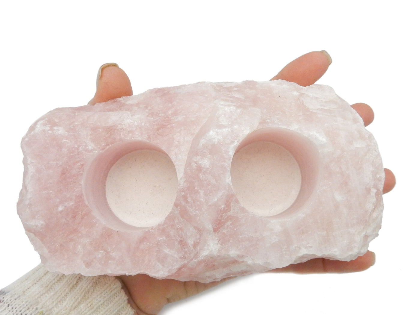 Hand holding up Rose Quartz Candle Holder revealing top view on white background