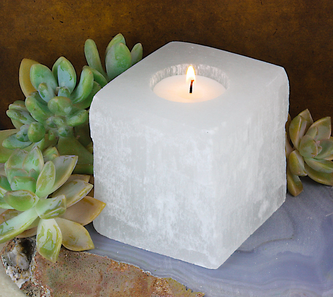 Square Shaped Selenite Candle Holder with a candle lit up (candle not included)