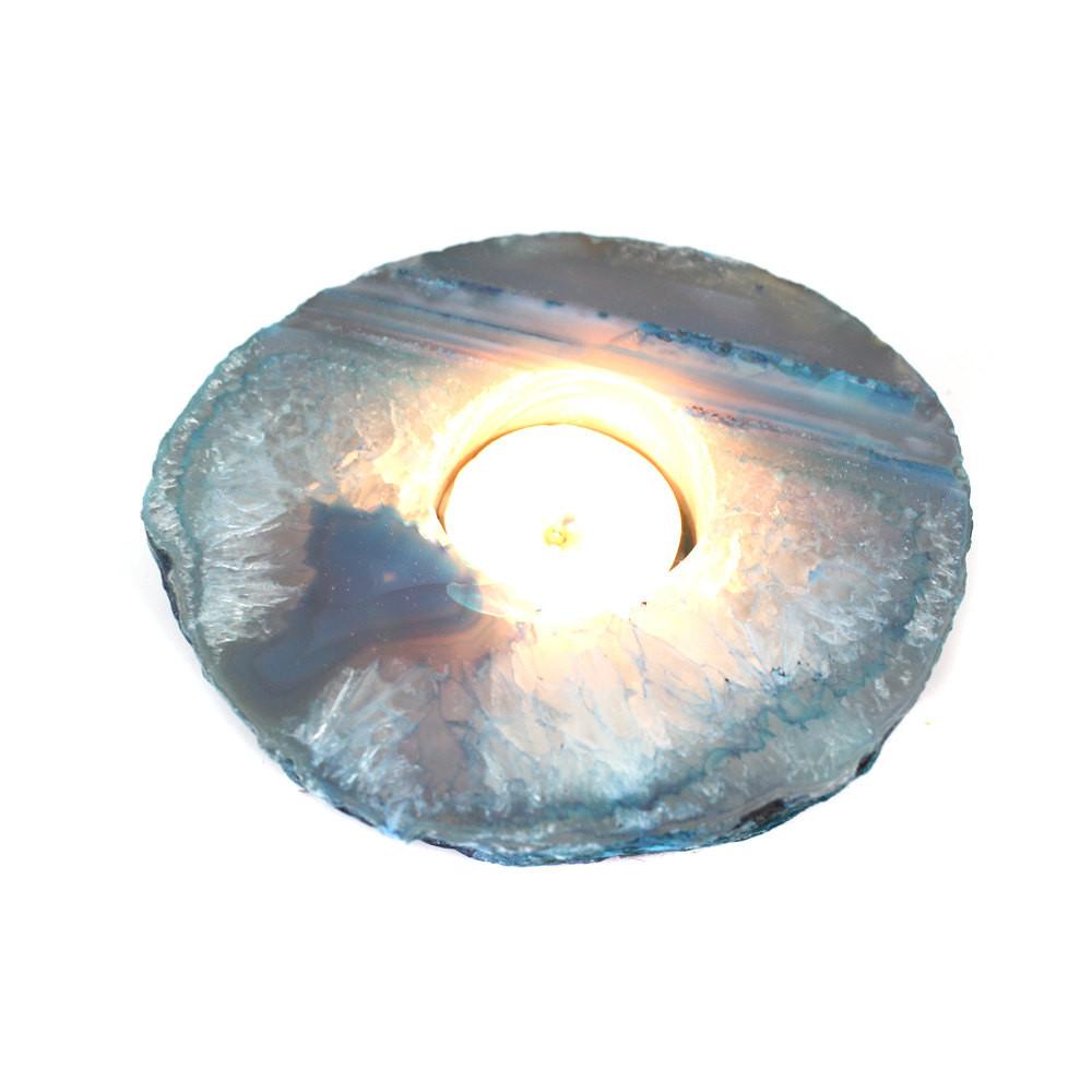 teal agate candle holder with a candle lit up in it