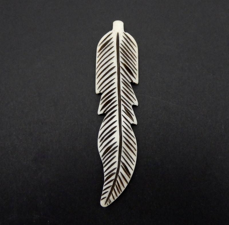 1 carved bone feather on a black background
