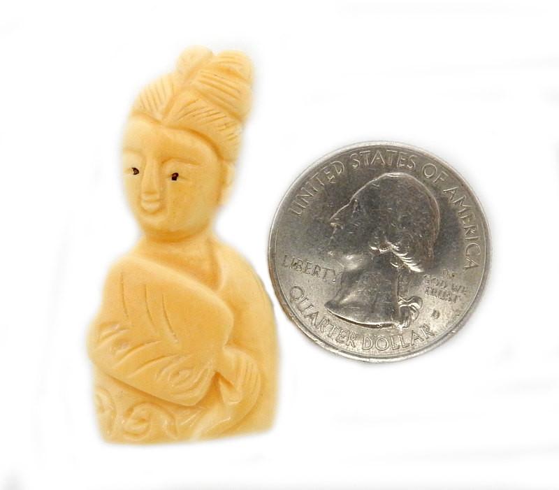 1 carved bone woman on a white background next to a quarter