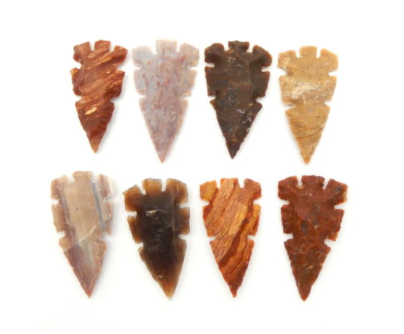 8 jasper arrowheads lined in rows of 4 on a white background