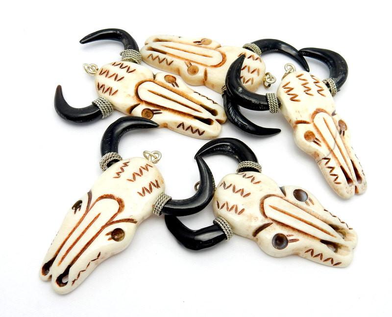 5 bone carved cattle heads on a white background