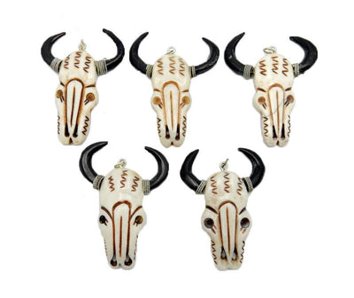 5 bone carved cattle head laid out on a white background