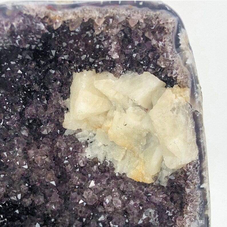 close up of the white calcite on the amethyst clusters of the geode.