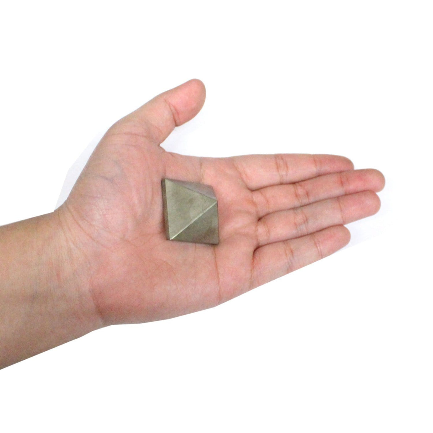 Side view of Pyrite shaped pyramid in palm of hand.