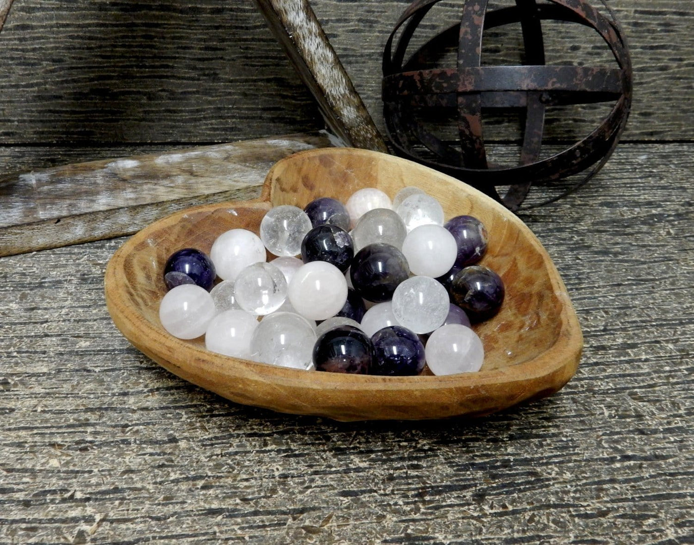 Photo of assorted spheres in a wood heart bowl.