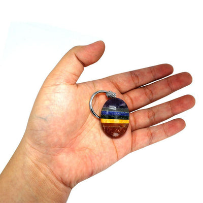 seven chakra worry stone keychain in hand for size reference