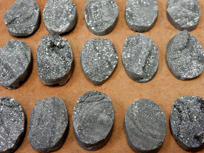 Mystic Platinum  Titanium Chalcedony Druzy Oval Cabochons spread out on a table showing variation in druzy