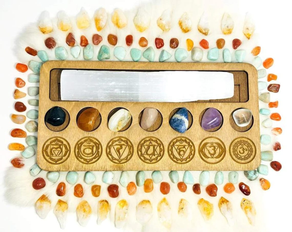 Chakra and Selenite Charging Set--top shot view of stones on wood with symbols.