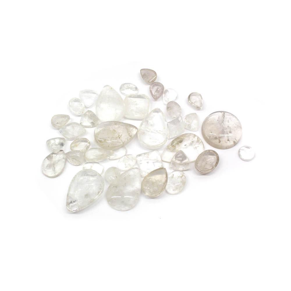 1/4 lb bag of Mixed Shapes Clear Crystal Cabochons displayed on white background with shapes such as teardrops ovals circles diamonds rounded squares