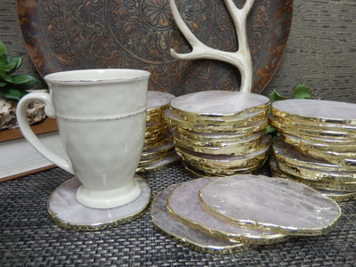 Stone Slices - Coaster Size rose quartz with gold edge shown here with a cup on one.
