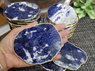 sodalite Stone Slices  stacked up with one in a hand for size reference