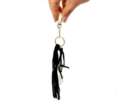 hand holding up crystal keychain with black leather on white background