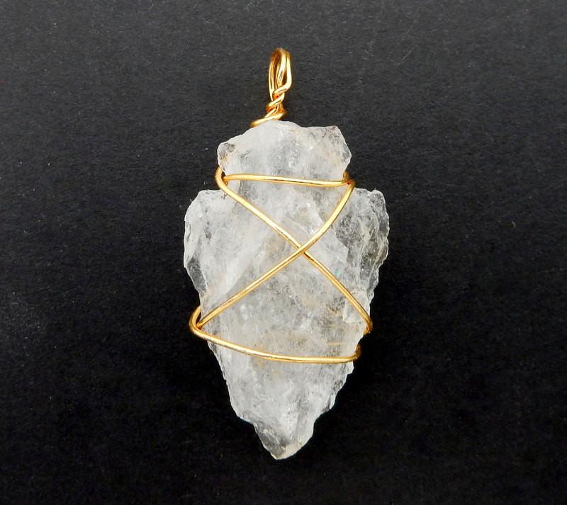 close up of a gold wire wrapped crystal quartz arrowhead 