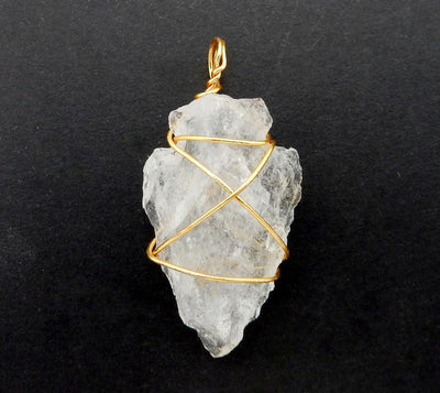 close up of a gold wire wrapped crystal quartz arrowhead 