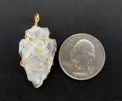 wire wrapped arrowhead next to a quarter for size reference 