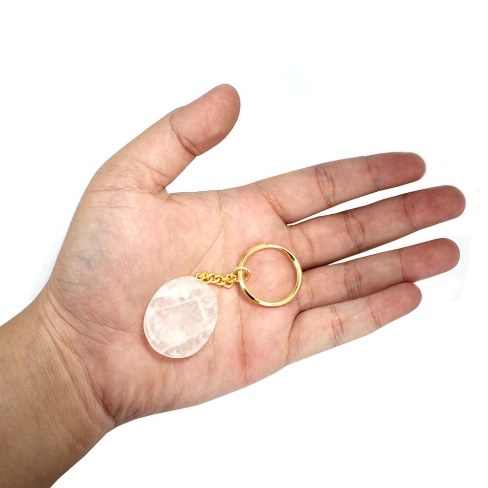 crystal Quartz Worry Stone Keychain displayed in hand to show size reference
