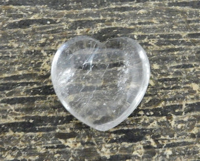 crystal quartz heart with decorations in the background