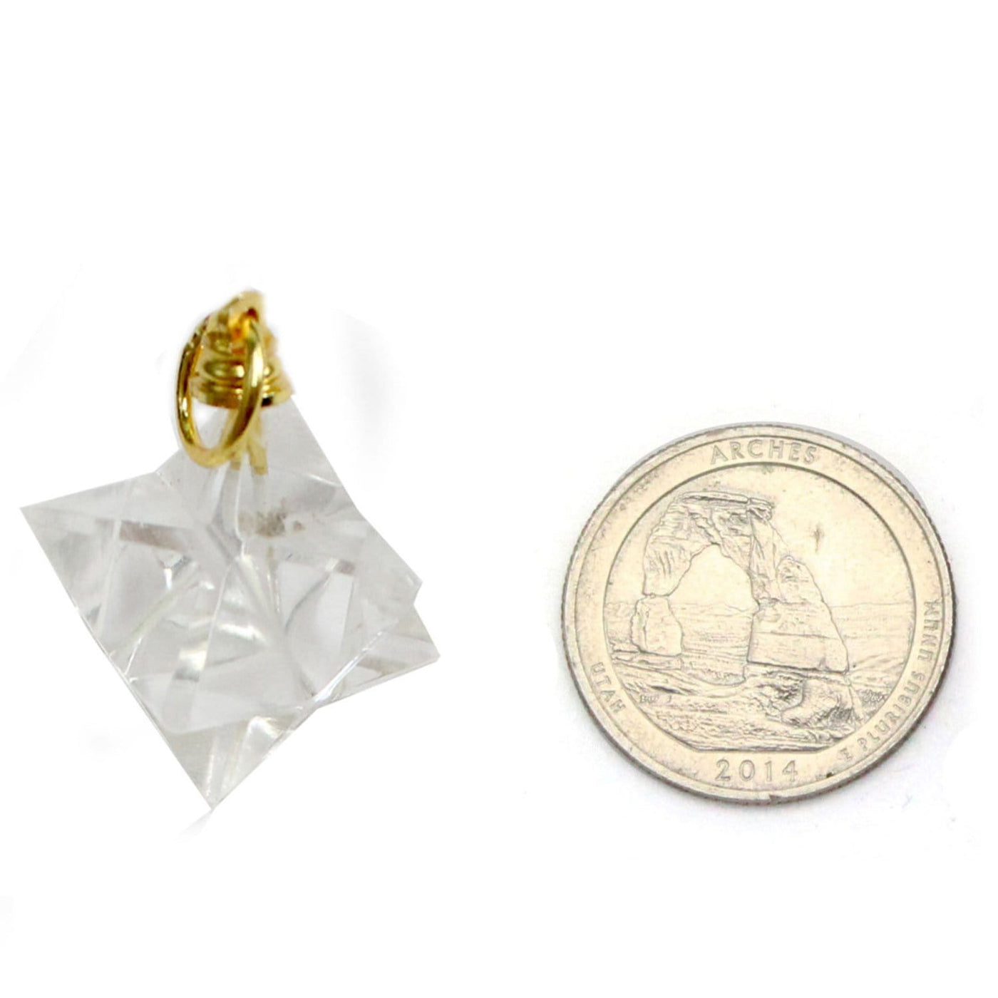 crystal quartz merkaba star pendant next to a quarter for size reference