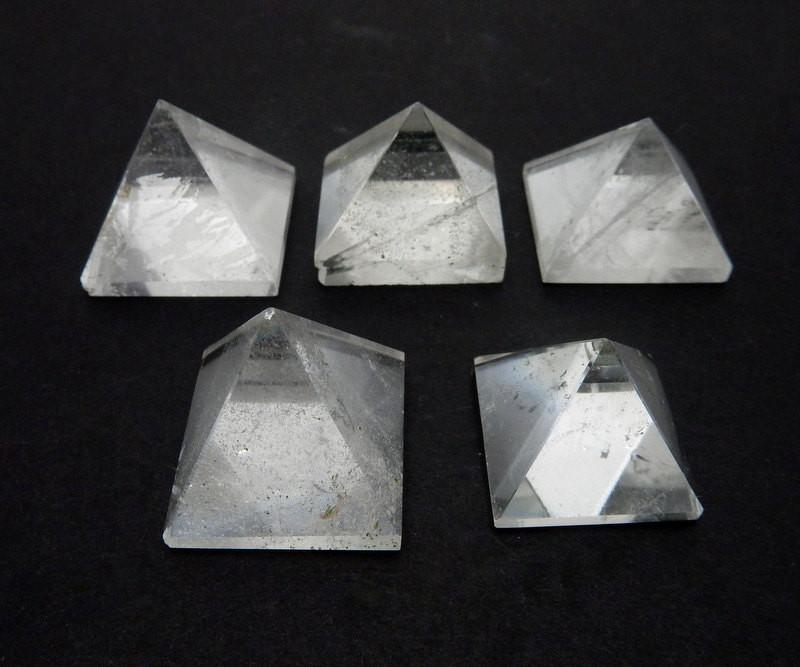 5 crystal pyramids on a table