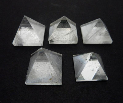 5 crystal pyramids on a table