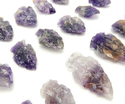 Picture of amethyst arrowheads displayed on a white back ground .
