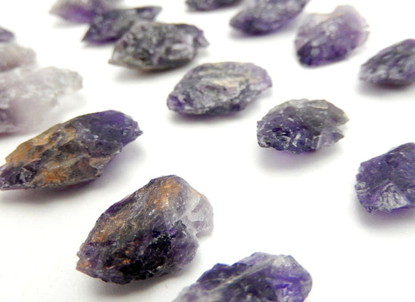 Picture of amethyst arrowheads displayed on a white back ground.