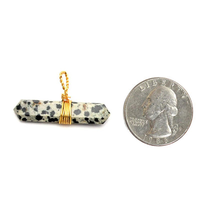 Gold Tone Wire Wrapped Dalmatian Jasper Double Point Pendant Next to a Quarter on White Background.