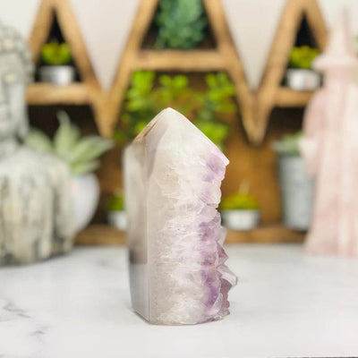 side view of Amethyst Druzy Polished Tower Point with decorations blurred in the background