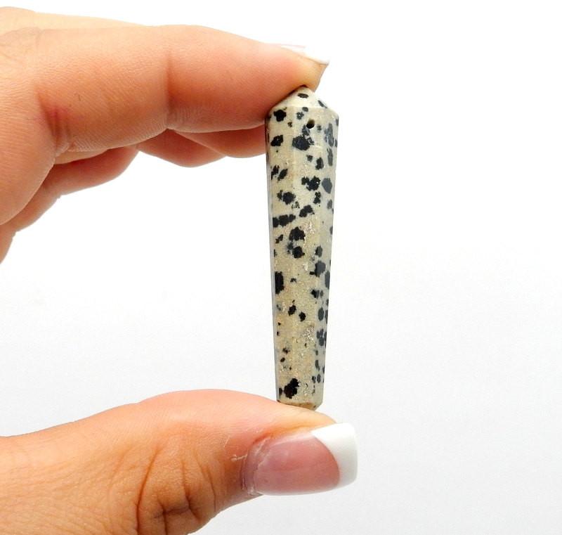 Dalmatian Jasper Double Terminated Pencil Point Top Side Drilled Bead Gripped on Fingers on White Background.