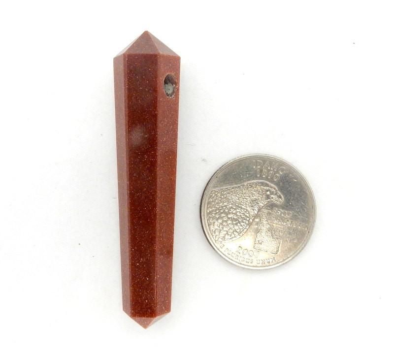 Goldstone Pencil Point Bead next to a quarter for size reference