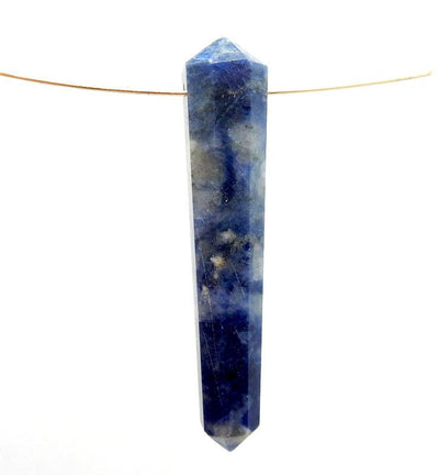 close up of one sodalite double terminated pencil point bead on white background with wire running through drilled hole