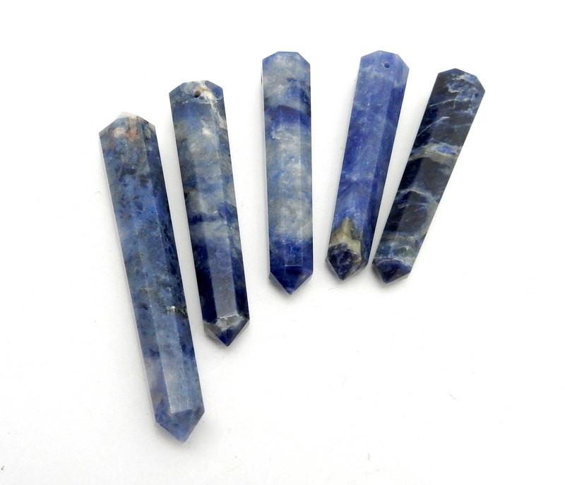 five sodalite double terminated pencil point beads in a row on white background for possible variations