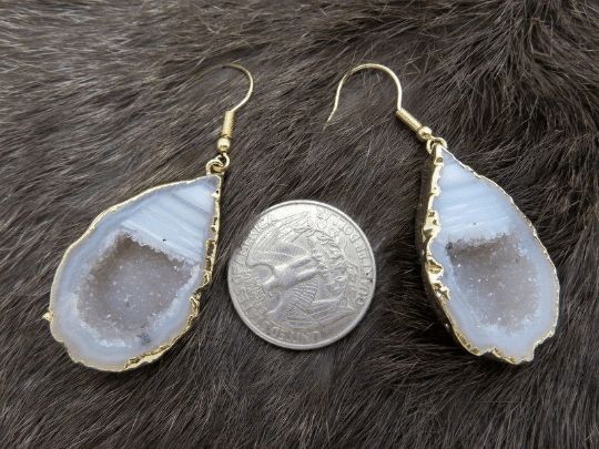 One pair of agate geode dangle earrings next to a quarter for size reference.
