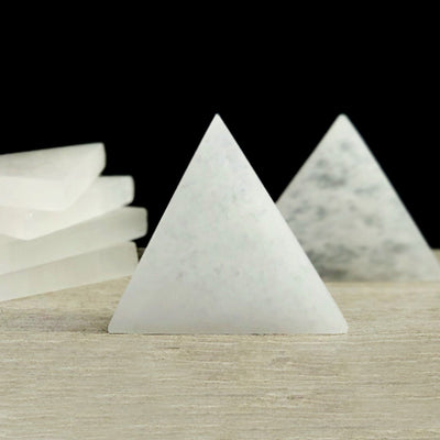 close up of one selenite triangle charging plate propped up with others in background