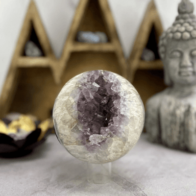 Amethyst sphere with an open center that contains an amethyst cluster.