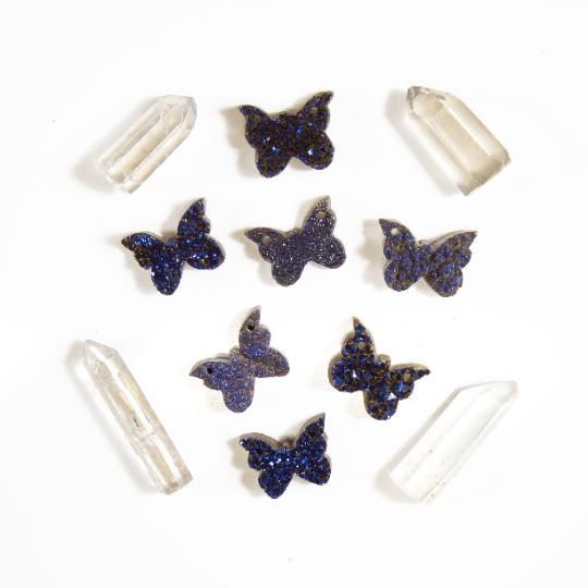 7 druzy butterfly pendants with other crystals on white background