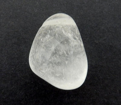 Drilled Tumbled Stone Crystal Quartz Polished Bead on Black Background.