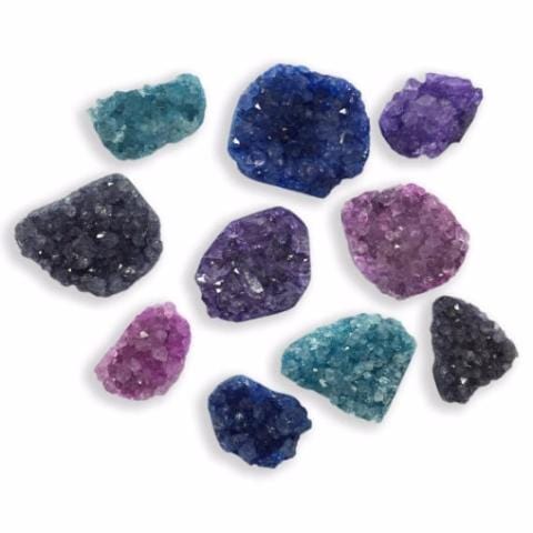 Assorted druzy in shades of blue, teal, purple, and pink on a white background.