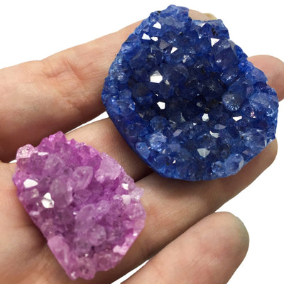 Blue and pink druzy clusters in a hand.