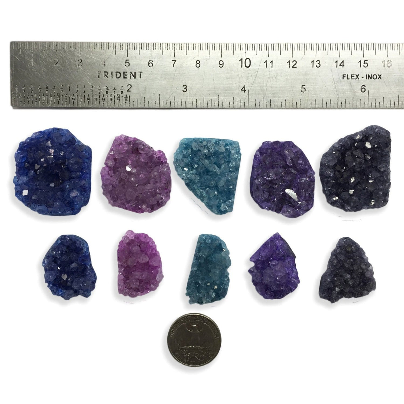 Assorted druzy in shades of blue, teal, purple, and pink on a white background with a ruler next to them showing they are from half an inch to an inch.