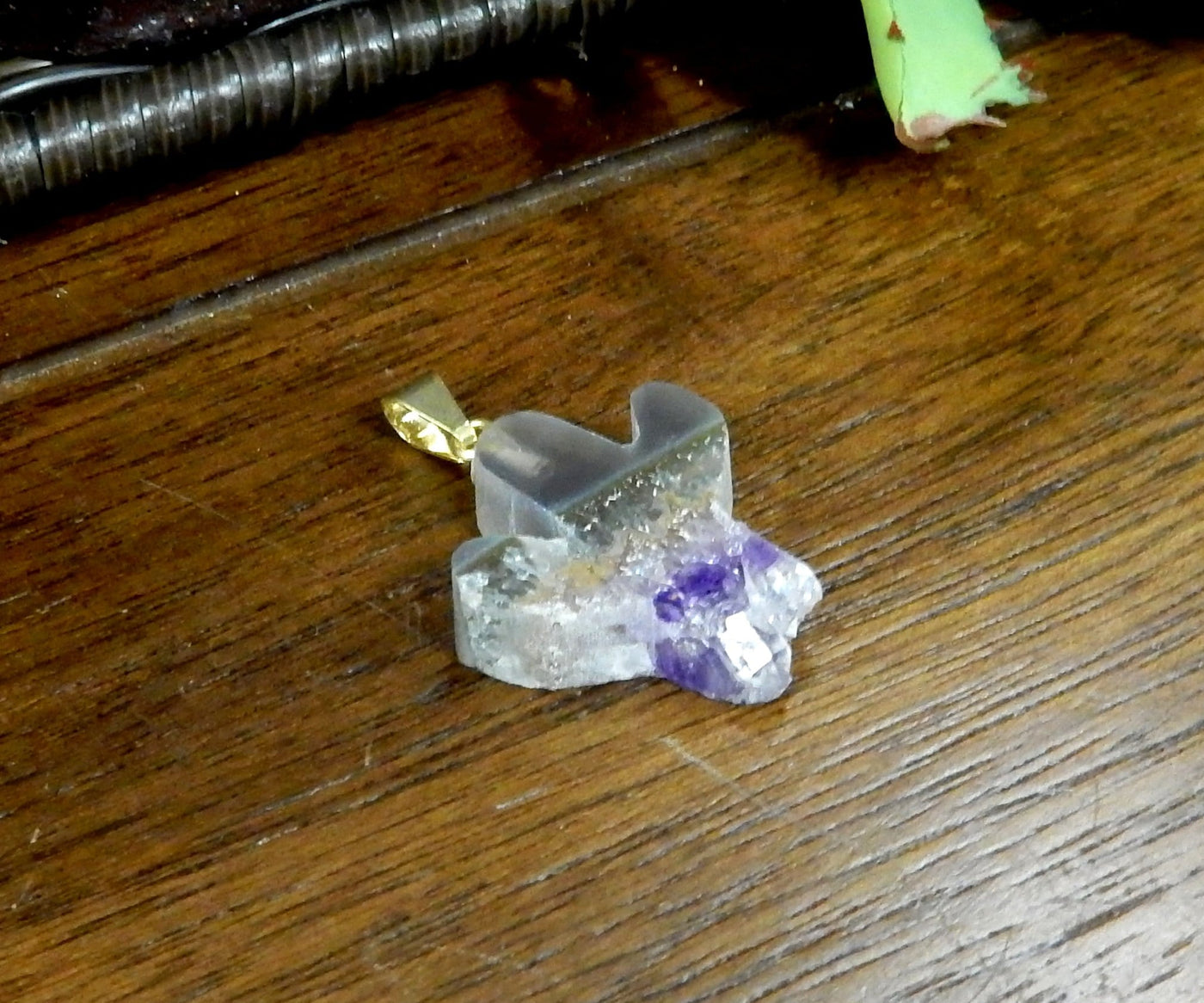 angled shot of amethyst slice cactus pendant on wooden table