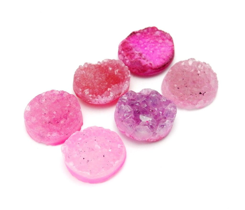 side view of multiple Pink Round Shaped Druzy Cabochons for thickness reference
