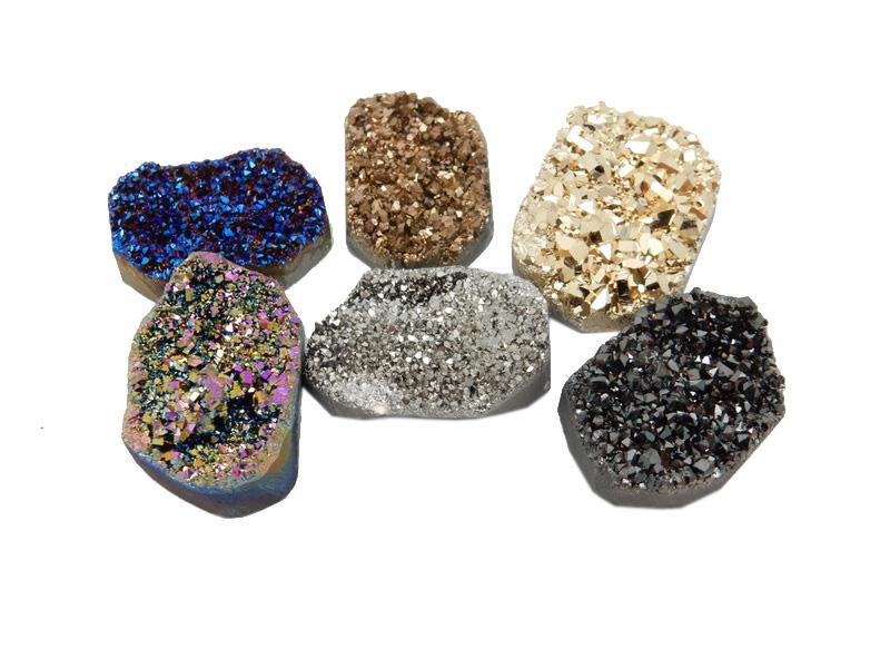 6 different colored titanium druzy clusters on white background