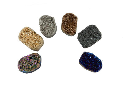 6 different titanium druzy clusters in a semicircle on white background