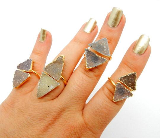 hand wearing 4 druzy triangle rings 