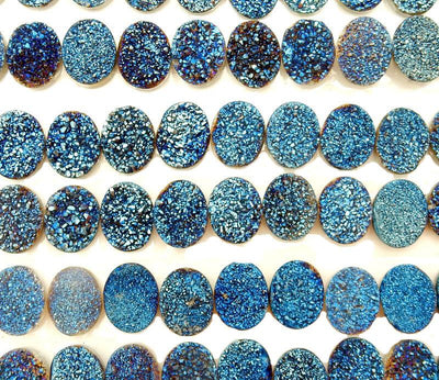 multiple Blue Oval Shaped Druzy Cabochons displayed on white background to show various druzy formations and different hues of blues