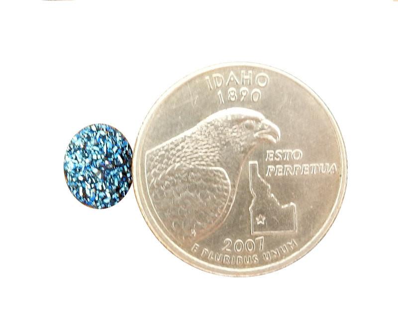 Blue druzy Cabochon displayed next to quarter for size reference